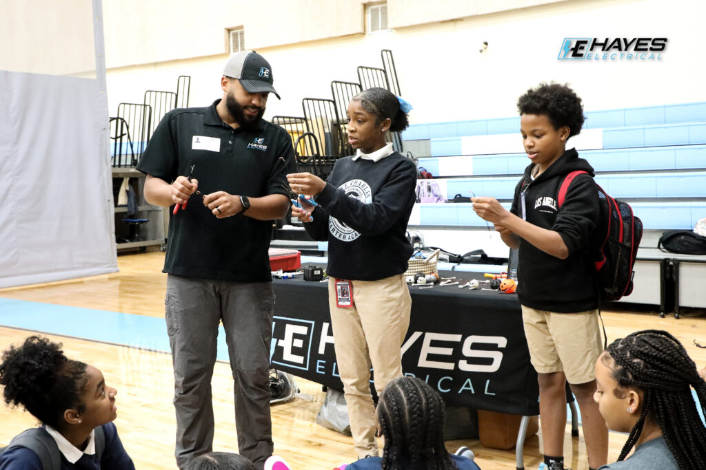 The Hayes Electrical team actively engages with local students, demonstrating basic electrical concepts and the safe use of tools.