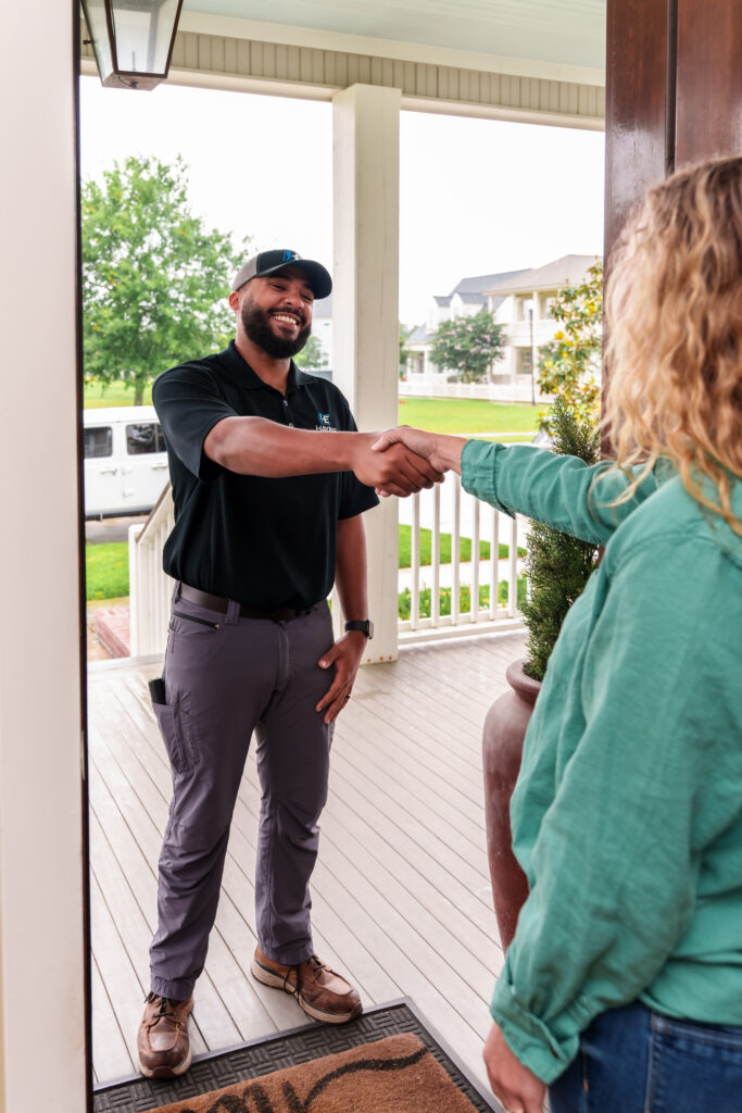 A friendly Hayes Electrical technician greets a customer at their home, ready to provide excellent service.